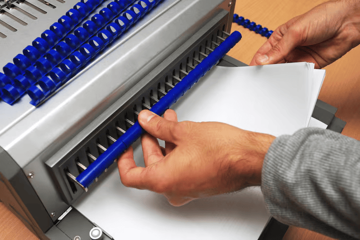 binding machine with man who works it-Apex Braille (Services) (Tactile Graphics)